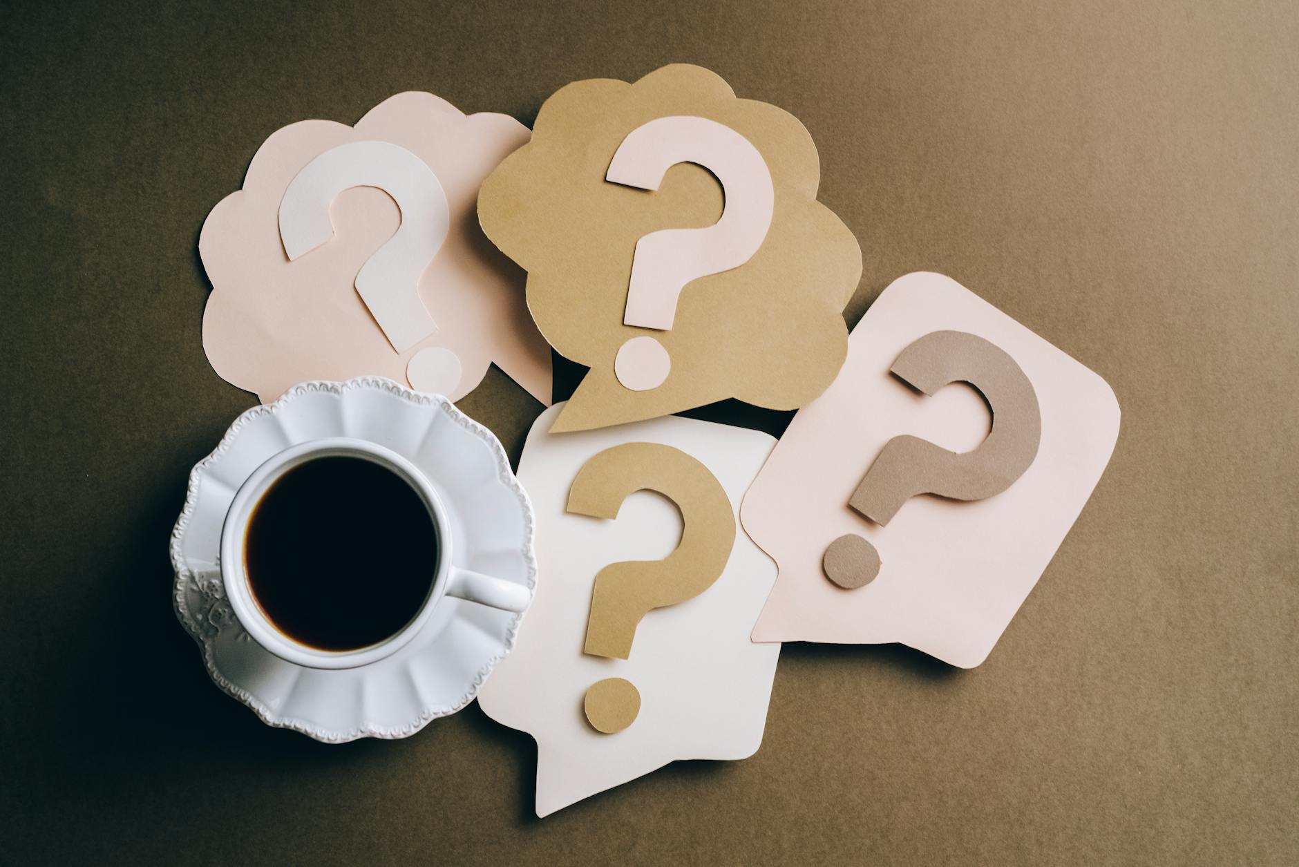 question marks on paper crafts beside coffee drink